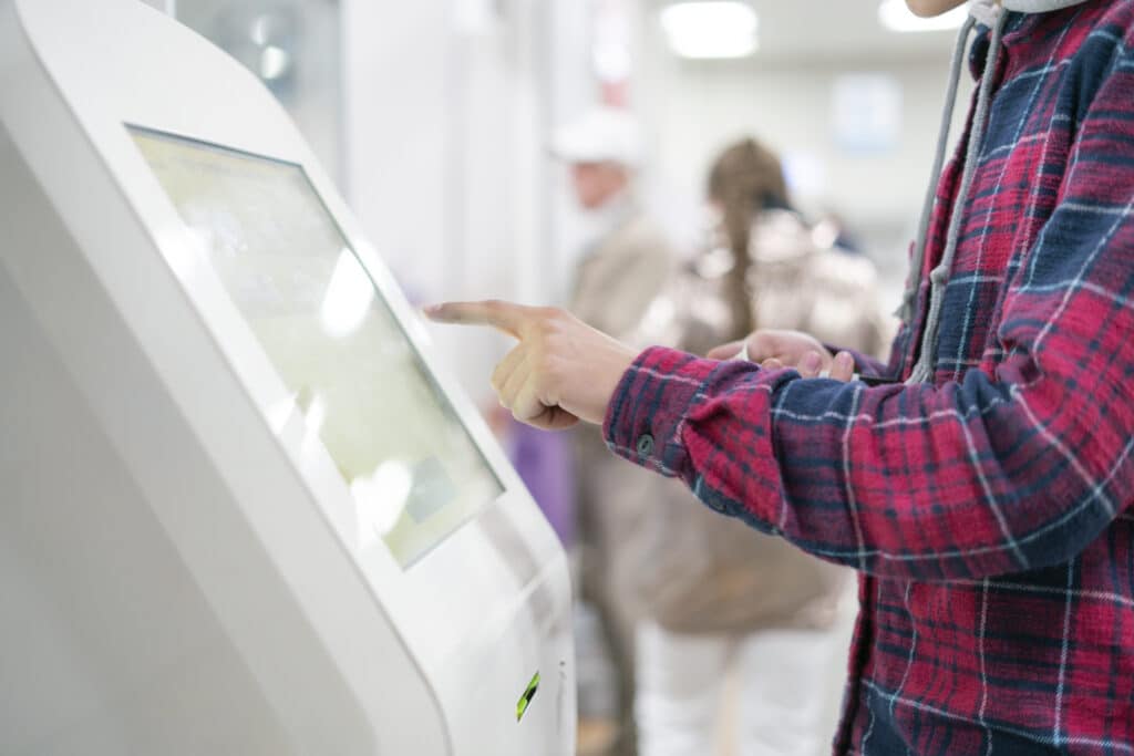 close up person using touch screen panel in post office to recieve a package